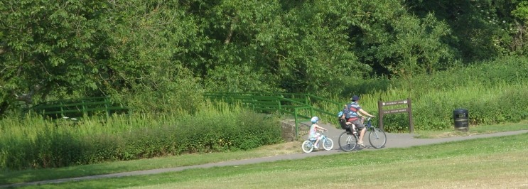 family-cycling-along-river